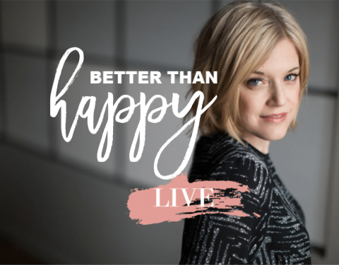 A woman with short blonde hair stands next to the text "Better Than Happy LIVE" written in large script and block letters on a blurred background.