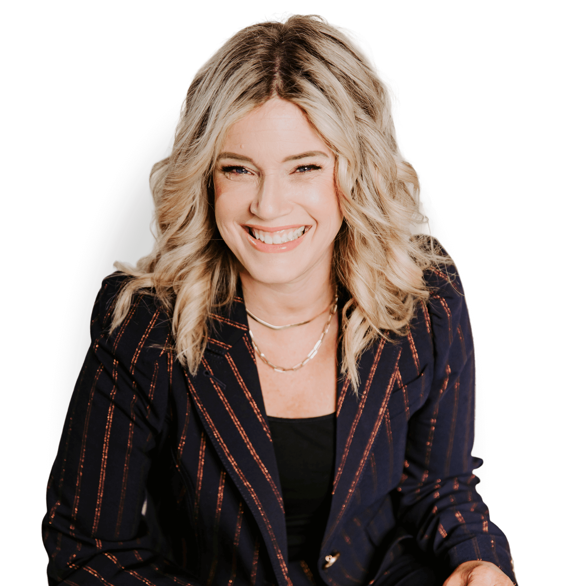 A woman with wavy blonde hair, wearing a dark pinstripe blazer and a necklace, smiles while looking at the camera against a black background.