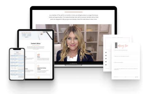 A laptop, tablet, and smartphone display a digital library and a woman speaking on video; two printed worksheets are positioned beside the devices.